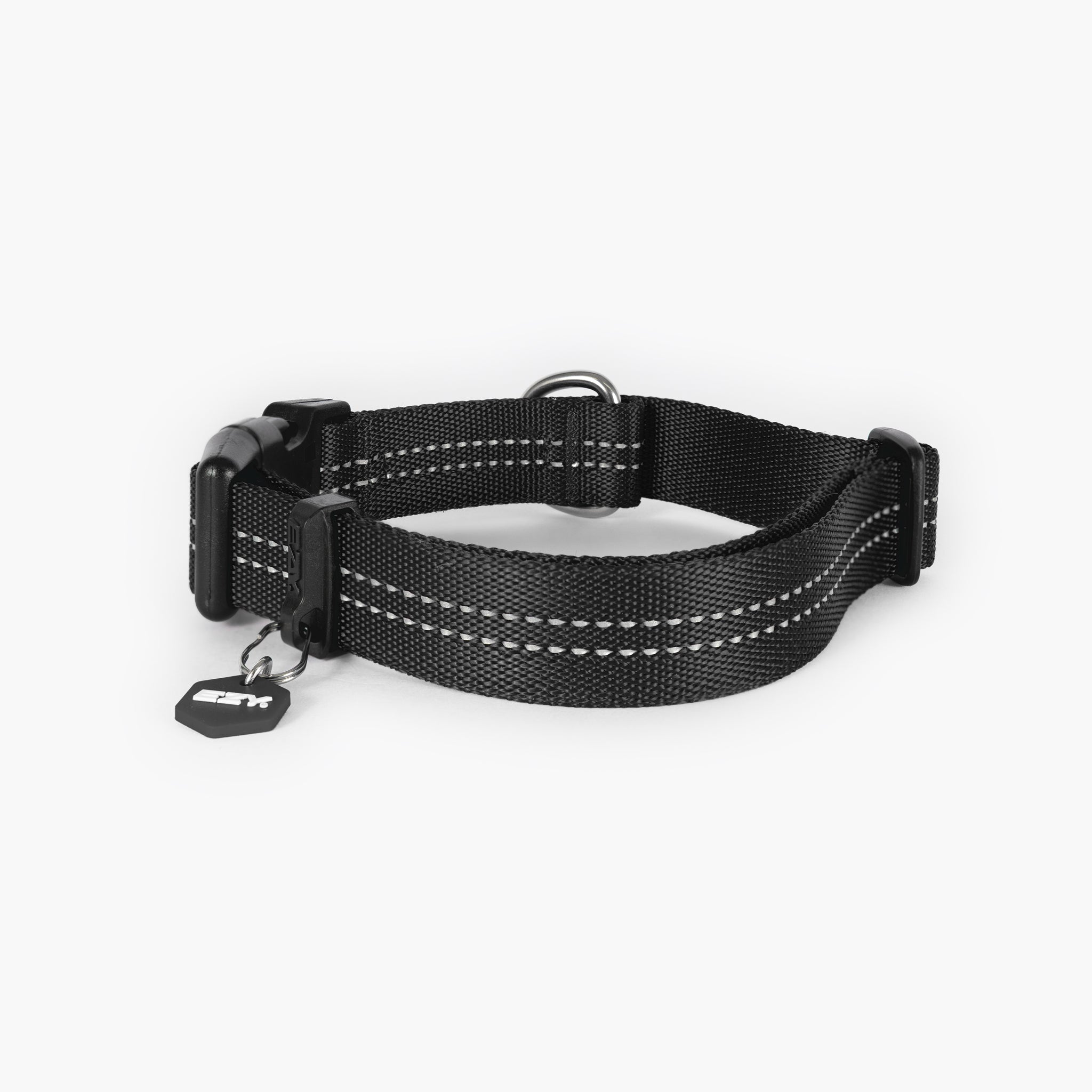 Black dog collar with white stitching on a light gray background