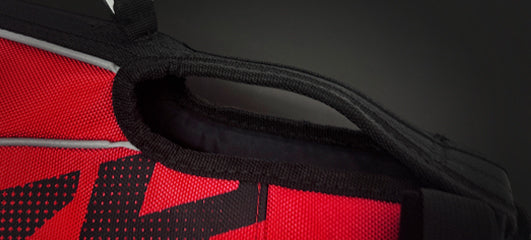 Close-up of the Neoprene Grab Handle and strap on a red EzyDog harness, featuring reflective trim for visibility.